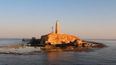 Deniz feneri ile dramatik günbatımı