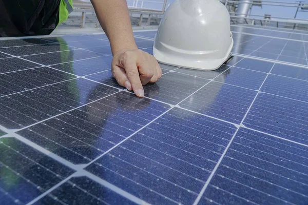                                Beyaz şapkalı bir elektrik mühendisi kontrol ediyor. Binanın çatısında güneş paneli temizliği..