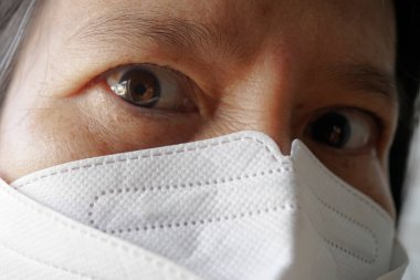 Maske takan yaşlı Asyalı kadınlar.