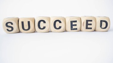 The word succeed on the block of wood.