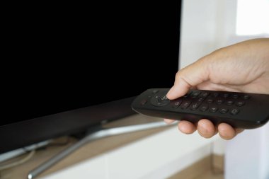 Asian old woman presses the remote