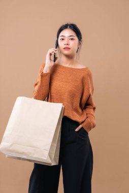 Alışveriş torbaları tutan mutlu Asyalı kadın..