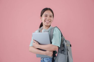 Genç Asyalı kız sırt çantası pembe arka plan.