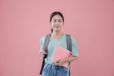 Genç Asyalı kız sırt çantası pembe arka plan.