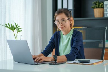 Evde çalışan Asyalı genç bir kadının portresi..