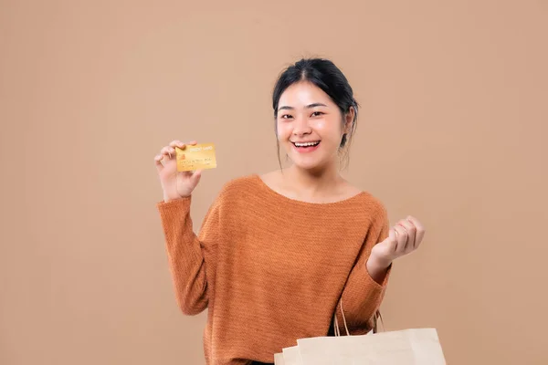 Happy Asian woman holding paper shopping bags enjoying shopping.