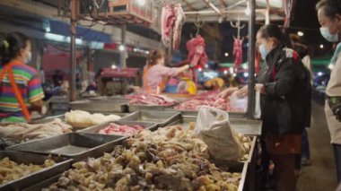 Bangkok, Tayland - 8 Şubat 2022 Sokaktan alışveriş yapan insanlarla dolu bir gece marketi. Tayland sokak yiyecekleri gece pazarı.