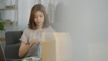 İş yerinde dizüstü bilgisayar kullanan, internetteki kadın girişimci paket kutuları hazırlayan, ekommerce postasını kontrol eden çevrimiçi perakende satış ve ticaret mağazası siparişi teslimat deposunda yerine getirildi..