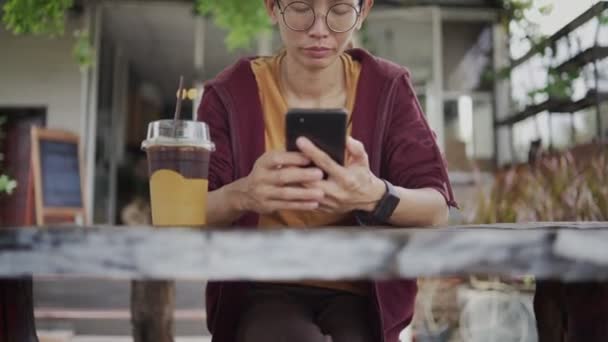 Young Asian Woman Using Smartphone Drinking Ice Tea Cafe Chatting — Video Stock