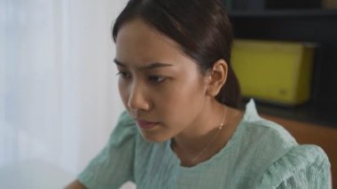 Asian woman feeling stress from work in the office.Tired business woman at workplace in office holding her head on hands feel headache.