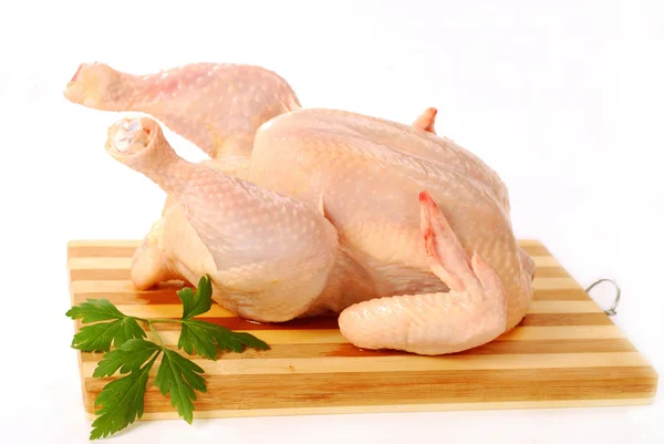 Сырая курица на деревянной доске — стоковое фото