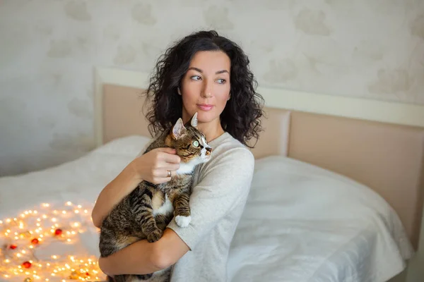 Young beautiful woman with cute cat resting at home. Domestic pet concept. Stock Image