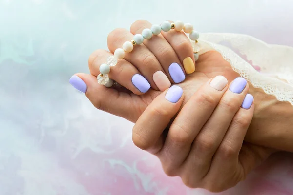 Primer plano de la manicura femenina con estilo en colores de moda del año 2022. Estilo moderno pastel color esmalte de uñas. —  Fotos de Stock