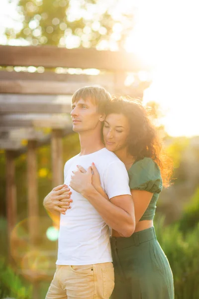Fiatal romantikus pár csókolózik és ölelkeznek naplementekor. Szerelem és boldogság fogalma. — Stock Fotó