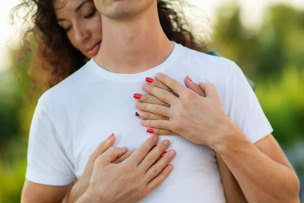 Nahaufnahme von jungen romantischen Pärchen, die sich umarmen und küssen. Frau umarmt Mann, konzentriert sich auf die Frauenhand. Familien- und Glückskonzept. — Stockfoto