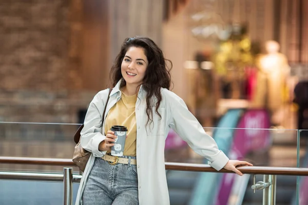 Genç ponpon kadın kağıt bardakta kahve içiyor. Evin içinde şık bir kadın..