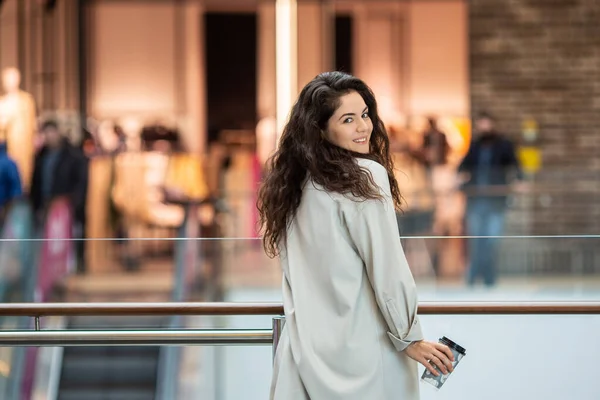 Genç ponpon kadın kağıt bardakta kahve içiyor. Evin içinde şık bir kadın..