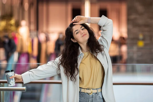 Genç ponpon kadın kağıt bardakta kahve içiyor. Evin içinde şık bir kadın..