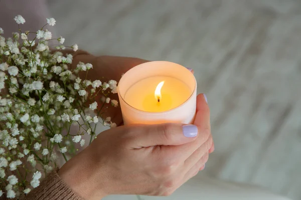 Elinde yanan mum tutan kadın. Kadın eli ve mum yakın çekim.