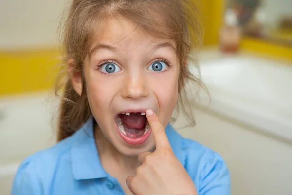 Beautiful little girl lost the first milk tooth. Happy child dropped the first milk tooth.