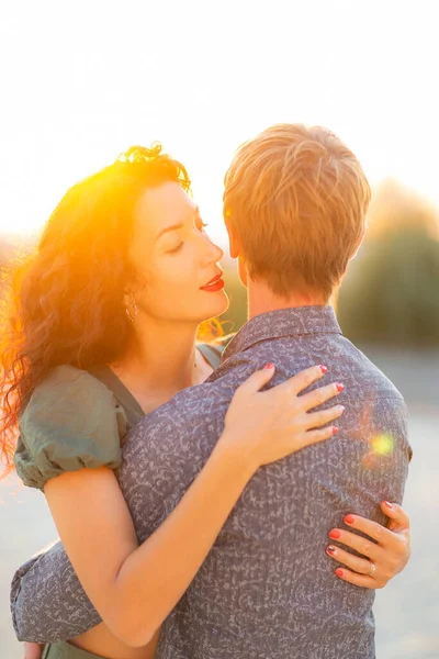 Junges romantisches Paar küsst und umarmt sich bei Sonnenuntergang. Konzept Liebe und Glück. — Stockfoto