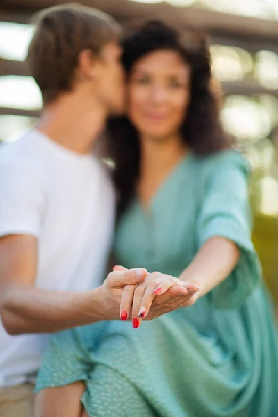 Junge Frau und Mann, die sich auf verschwommenem Hintergrund die Hände reichen. Familienkonzept. — Stockfoto