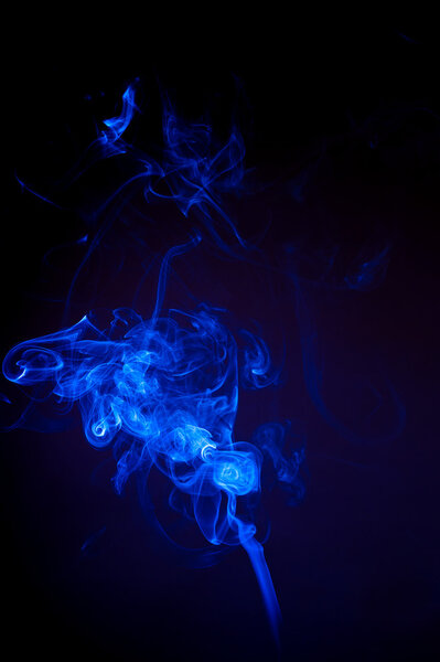 Colored smoke is moving on a black background