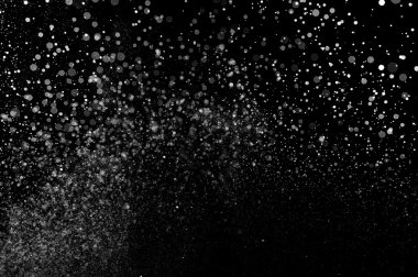 Siyah arka planda soyut su sıçramaları. Beyaz parçacıkların hareketlerini dondur. Yağmur, kar örtüsü dokusu.