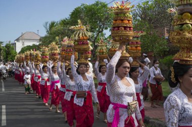 DENPASAR, 19 Haziran 2022: Denpasar Bali 'de geleneksel bir köyde geleneksel Bali kıyafetleri giyen kadınlar tarafından yapılan müdahaleye katıldı. Sıraya girdiler ve kafasında bir sürü meyve taşıdılar.