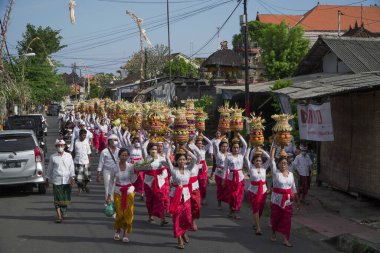 DENPASAR, 19 Haziran 2022: Denpasar Bali 'de geleneksel bir köyde geleneksel Bali kıyafetleri giyen kadınlar tarafından yapılan müdahaleye katıldı. Sıraya girdiler ve kafasında bir sürü meyve taşıdılar.