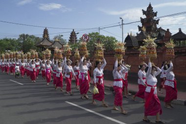 DENPASAR, 19 Haziran 2022: Denpasar Bali 'de geleneksel bir köyde geleneksel Bali kıyafetleri giyen kadınlar tarafından yapılan müdahaleye katıldı. Sıraya girdiler ve kafasında bir sürü meyve taşıdılar.