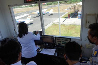 Buleleng, 2 Eylül 2022: Kuzey Bali, Yarbay Wisnu 'nun öncü havaalanında görevli bir hava trafik kontrolörü. Bazı tatbikat uçaklarına uçuş sinyalleri vermeye hazırlanıyor.