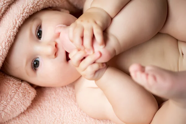 Adorable baby girl playing with her legs — Stock Photo, Image