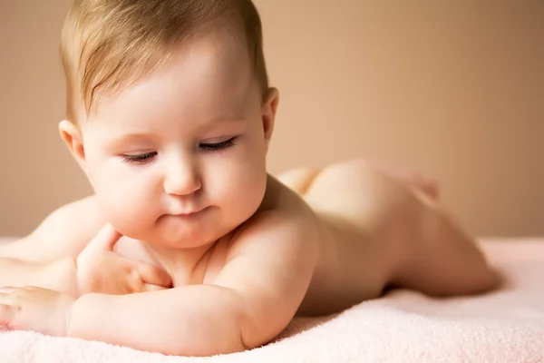 Affascinante bambina sdraiata sul suo stomaco — Foto Stock