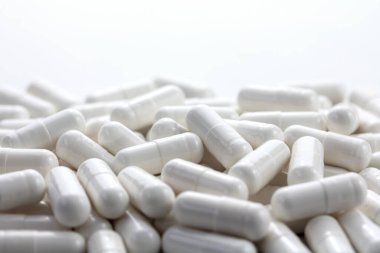 Sağlık ve tıp geçmişi var. Beyaz arkaplan üzerine beyaz kapsül yığını