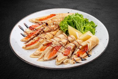 Kırmızı havyar ve somonla doldurulmuş gözleme. Rus yemeği. Siyah bir arkaplanda izole edilmiş