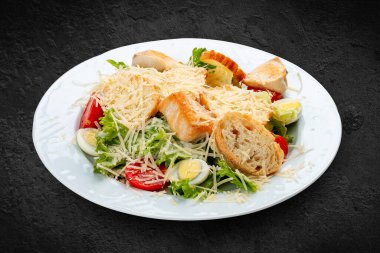 Tavuk, yumurta ve taze sebzeli Sezar salatası. Siyah bir arkaplanda izole edilmiş
