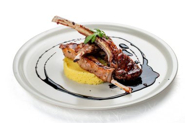 Kuskus ve vişne soslu kuzu pirzolası. Siyah bir arkaplanda izole edilmiş