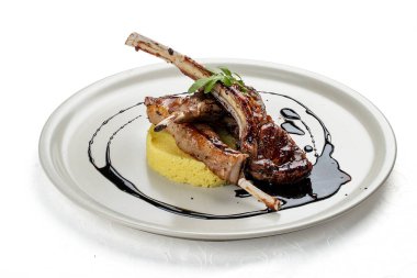 Kuskus ve vişne soslu kuzu pirzolası. Siyah bir arkaplanda izole edilmiş