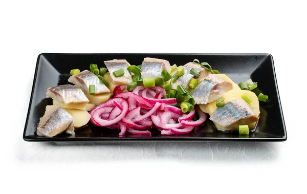 Hafif tuzlanmış ringa balığı, haşlanmış patates ve soğanlı aperatif. Beyaz bir arkaplanda izole edilmiş