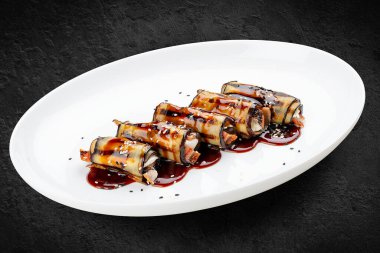 Patlıcan rulosu ve yılan balığı. Siyah bir arkaplanda izole edilmiş.