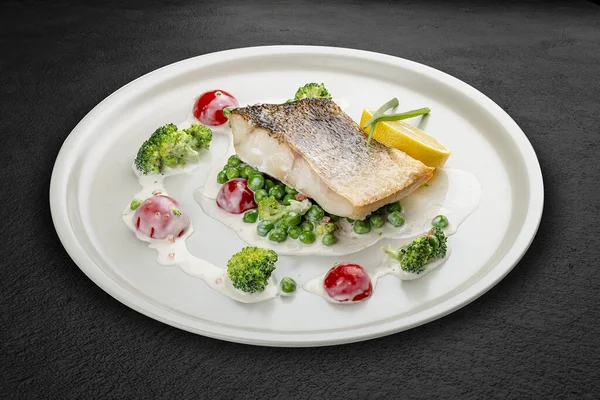 Sebze yastığına tünemiş levrek. Siyah bir arkaplanda izole edilmiş.