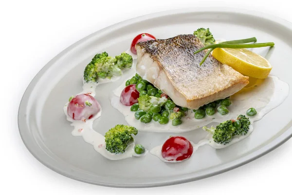 Sebze yastığına tünemiş levrek. Beyaz bir arkaplanda izole edilmiş.