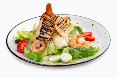 Beyaz dekoratif tabakta karidesli Sezar salatası. Klasik salata.. 