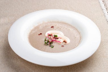 Beyaz tabakta mikro yeşil mantar çorbası.. 