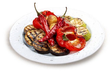 Beyaz bir tabakta ızgara sebze. Tatlı biber, domates, kabak, patlıcan..