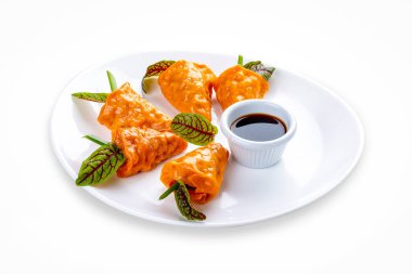 Manti with carrots and pumpkin. On a white background in a plate. Vegetarian dish. Isolated