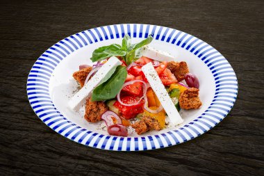 Feta peynirli Yunan salatası ve aromatik otlar. Karanlık bir arka planda, izole edilmiş. Vejetaryen yemeği..