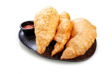 Cheburekler. Kıymalı yağda kızartılmış turtalar ve soslu soğan. Beyaz bir arkaplanda, izole. 