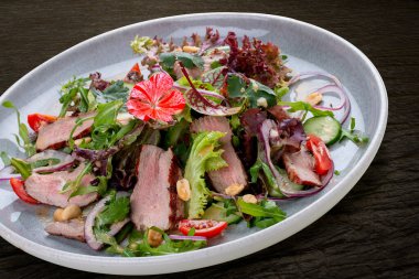 Josper-oven veal salad with sauce. On a dark background, isolated. 